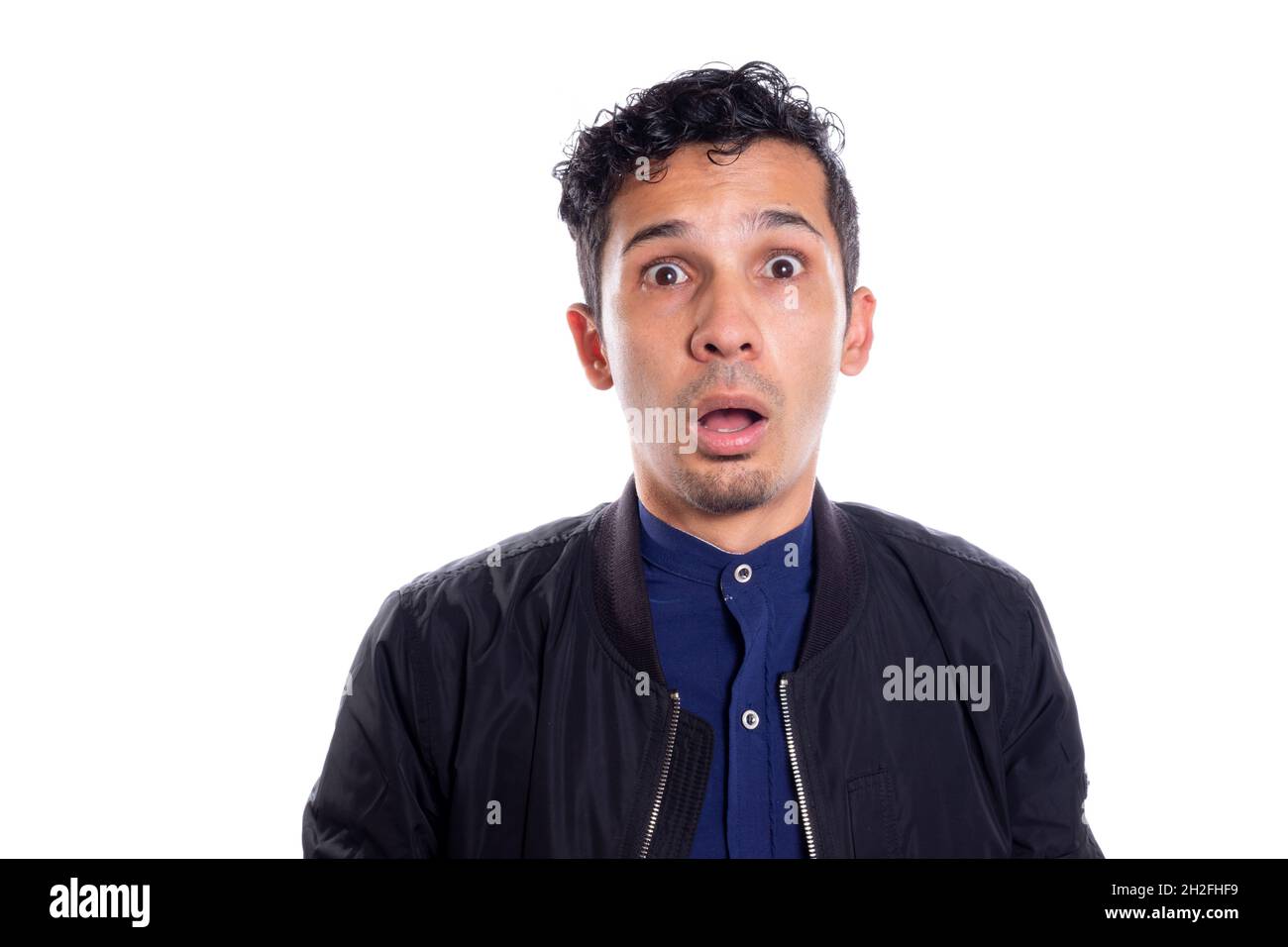 Surprised and frightened man, isolated on white background. Young adult astonished. Latin man. Stock Photo