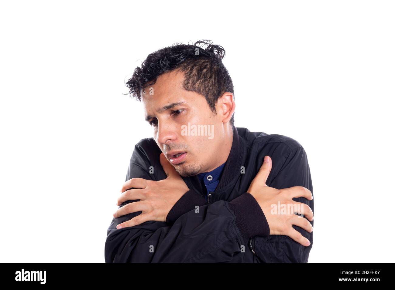 Latin man very cold and sick. White background. Stock Photo