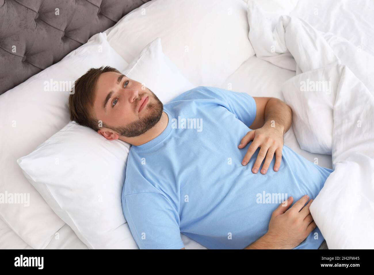 Young man lying in bed at home. Sleep disorder Stock Photo Alamy