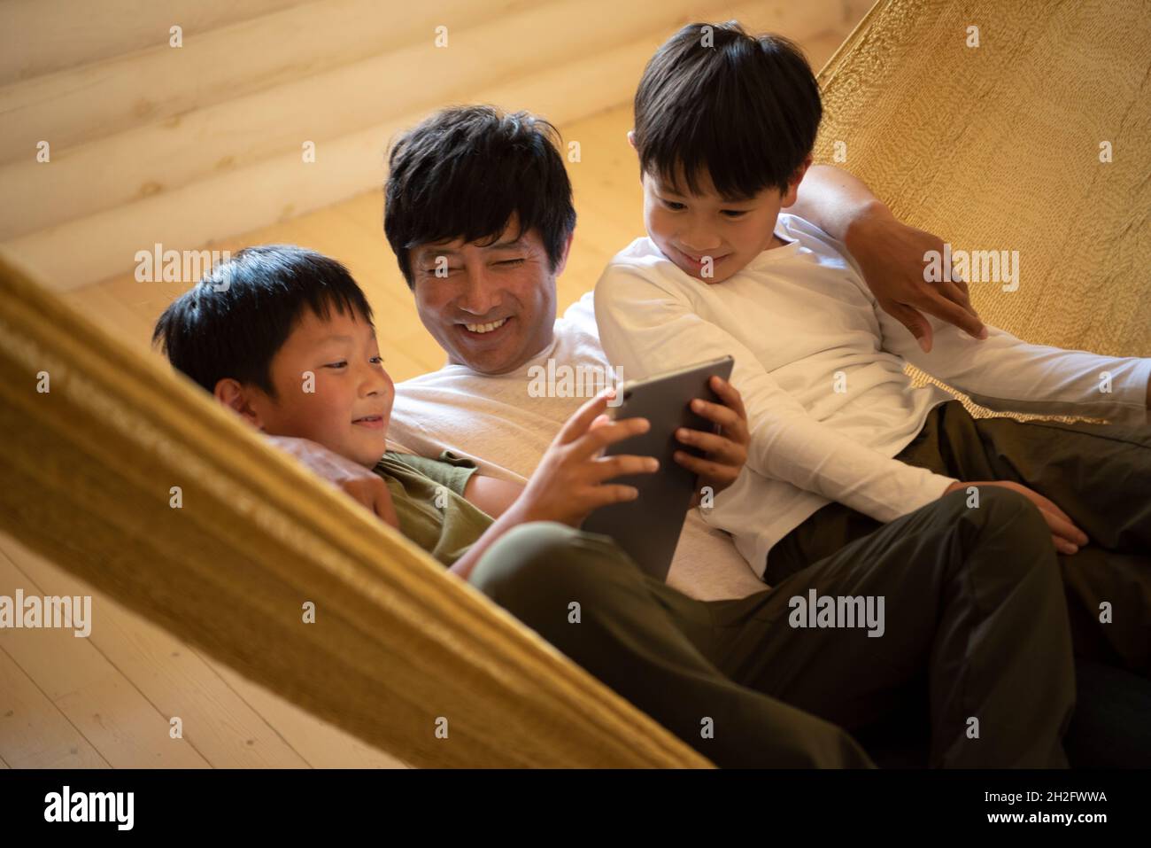 Father and Sons Relaxing in Hammock Stock Photo