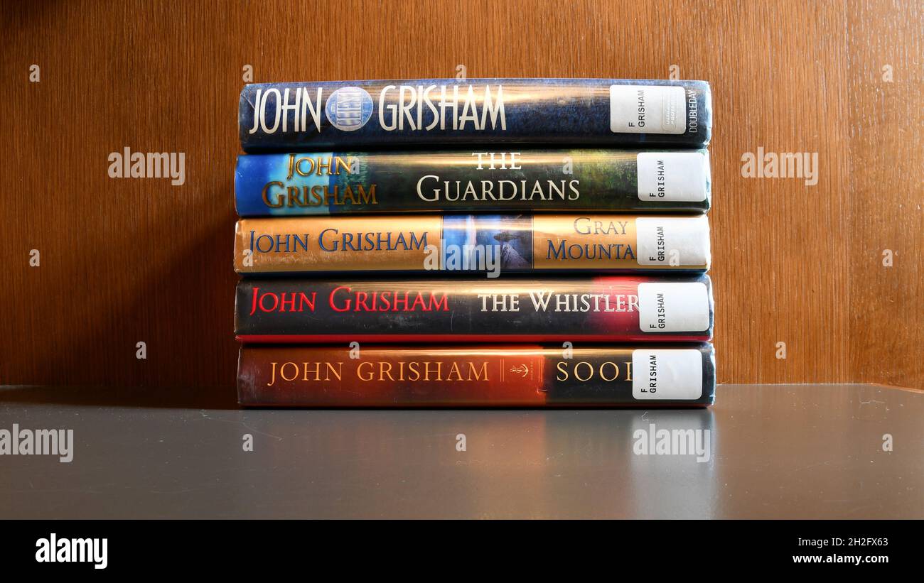 Assorted novels by American author John Grisham displaying the Dewey Decimal Classification system; legal thrillers Stock Photo