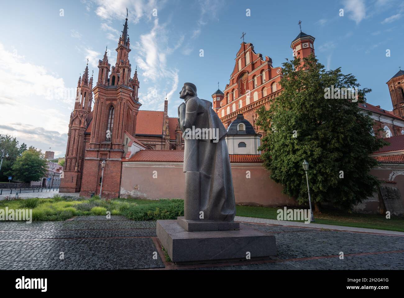 Adam Mickiewicz Monument (created by Gediminas Jokubonis in 1984) in front of Church of St. Anne and Bernardine Church - Vilnius, Lithuania Stock Photo
