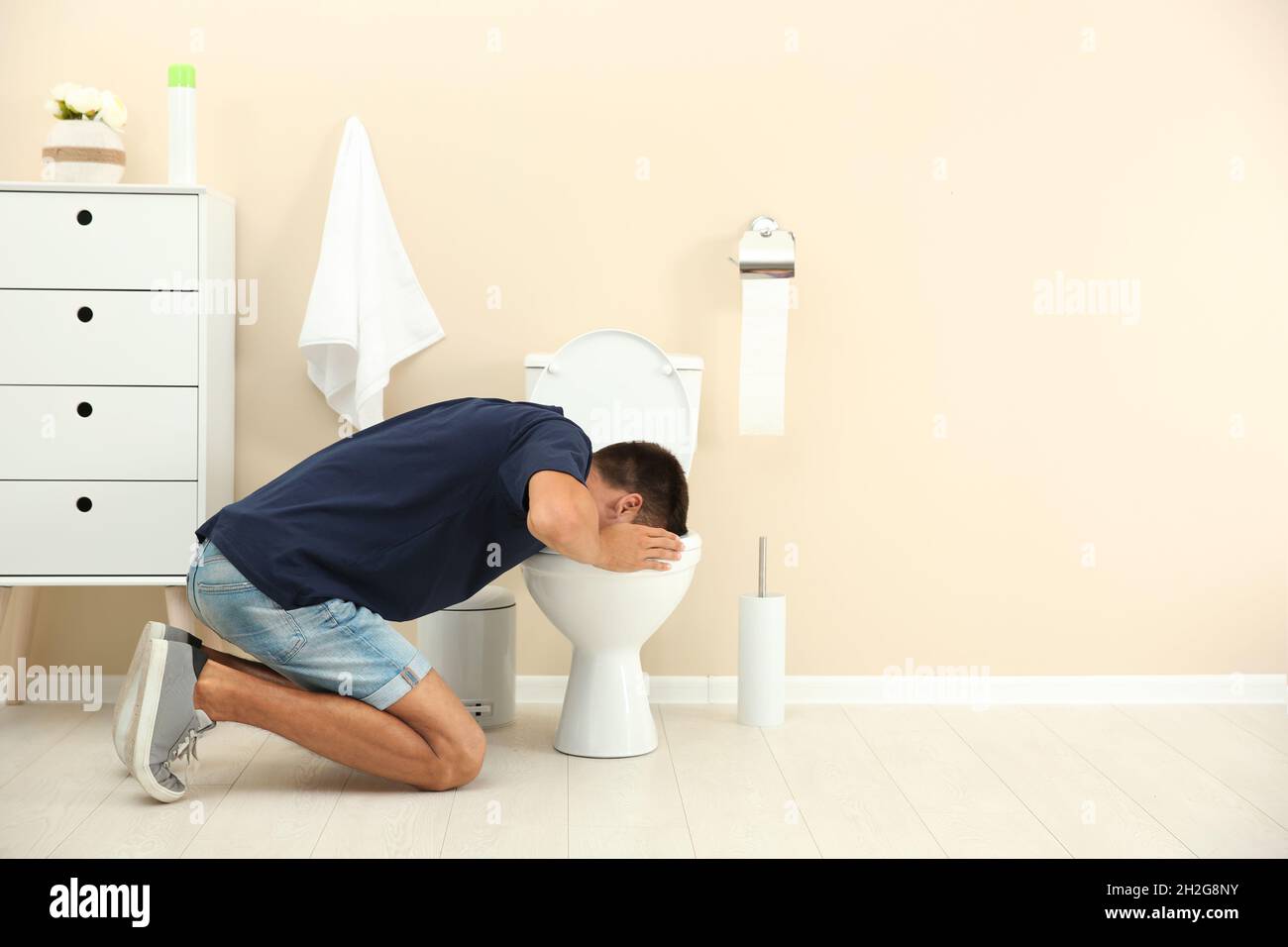 Young man vomiting in toilet bowl at home Stock Photo Alamy