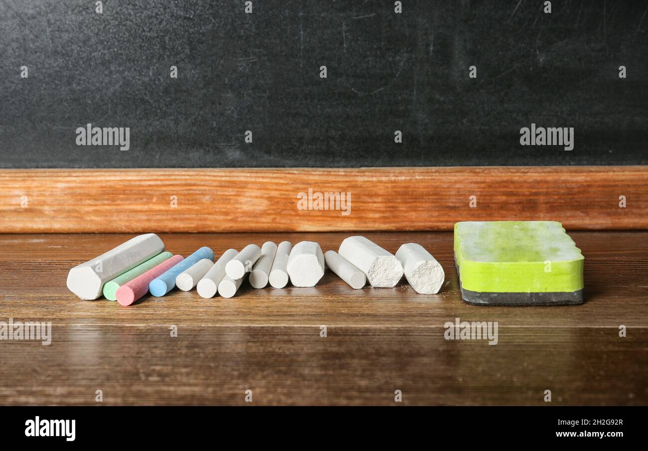 Chalk and duster on table in classroom Stock Photo Alamy