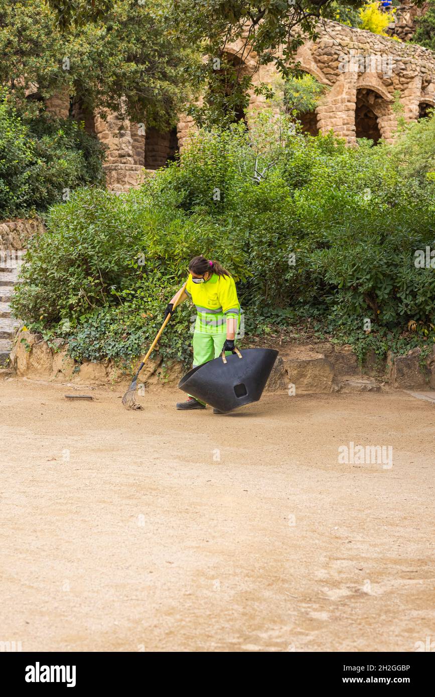 Barcelona, Spain - September 23, 2021: Cleaner on the parkway in Parc Guell. In the background the famous architecture. Famous tourist spot. Street cl Stock Photo