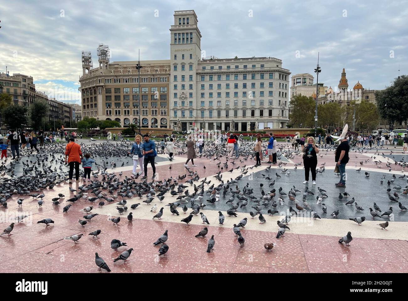 Barcelona, Spain - September 22, 2021: View over the Plaza Catalunya the heart of Barcelona. Tourist feeding the pigeons and taking pictures of the bi Stock Photo