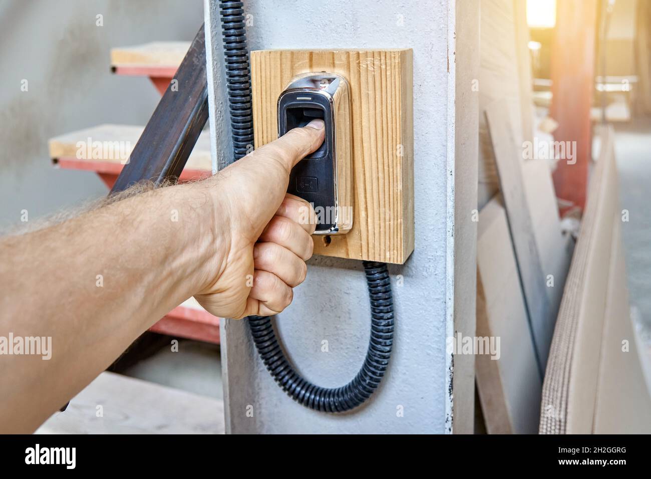 Worker uses contemporary biometric fingerprint scanner to record shift ...
