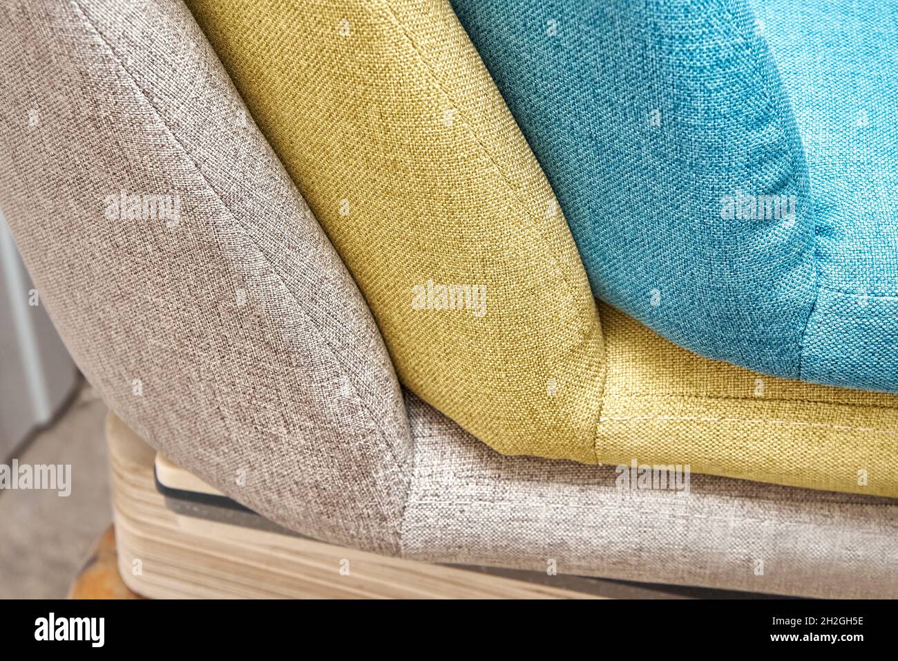 Colorful soft backs with vertical stitching of modern office chairs in light furniture assembling workshop at plant extreme closeup Stock Photo