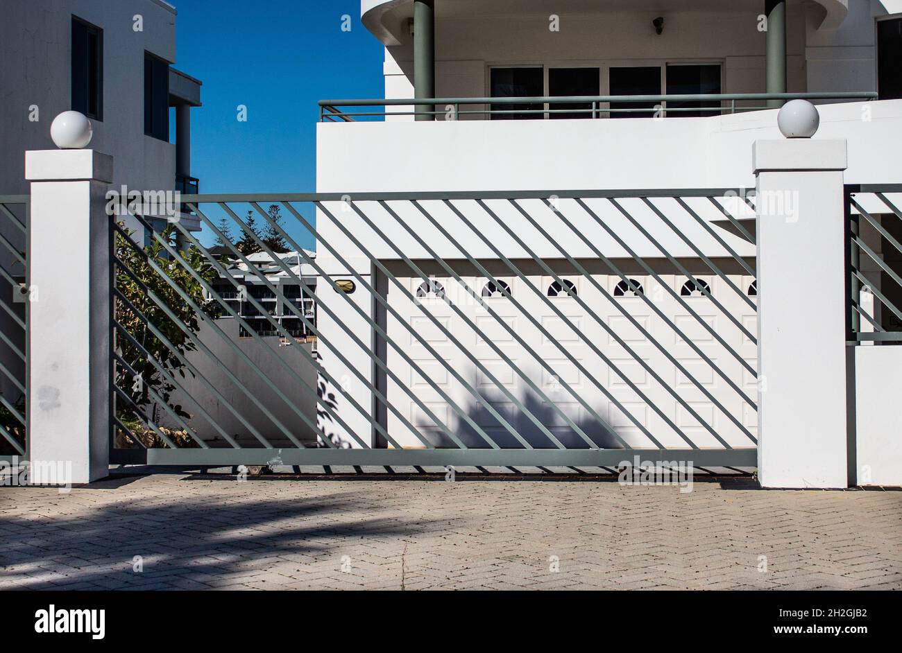 Grey modern metal driveway property entrance gates set in concrete