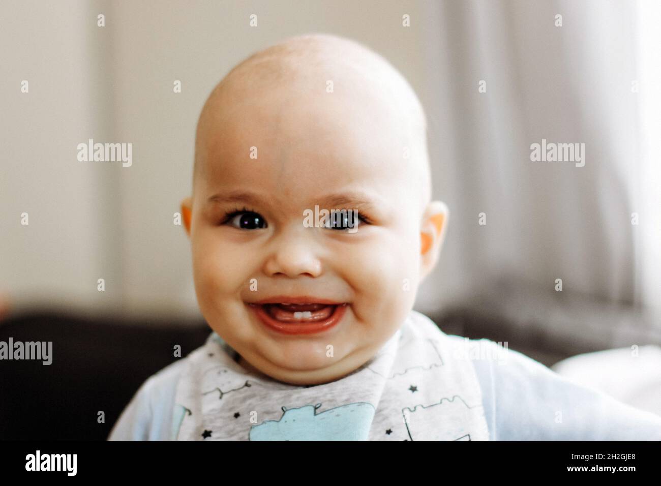 Sweet little baby boy with chubby cheeks and big eyes. Portrait of happy infant Stock Photo