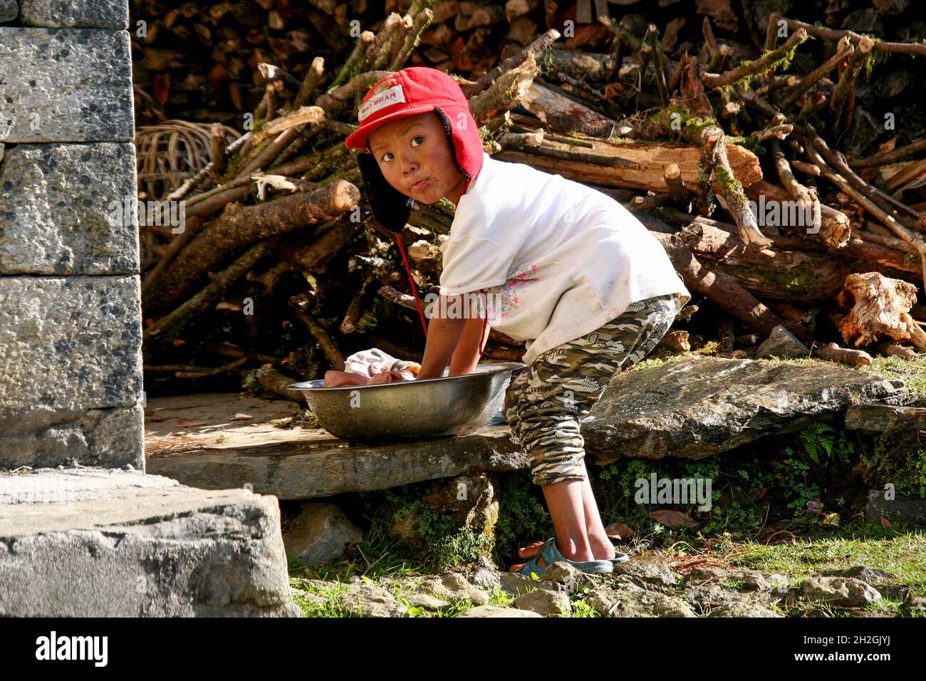 little boy washes his laundry alone in Nepal Stock Photo