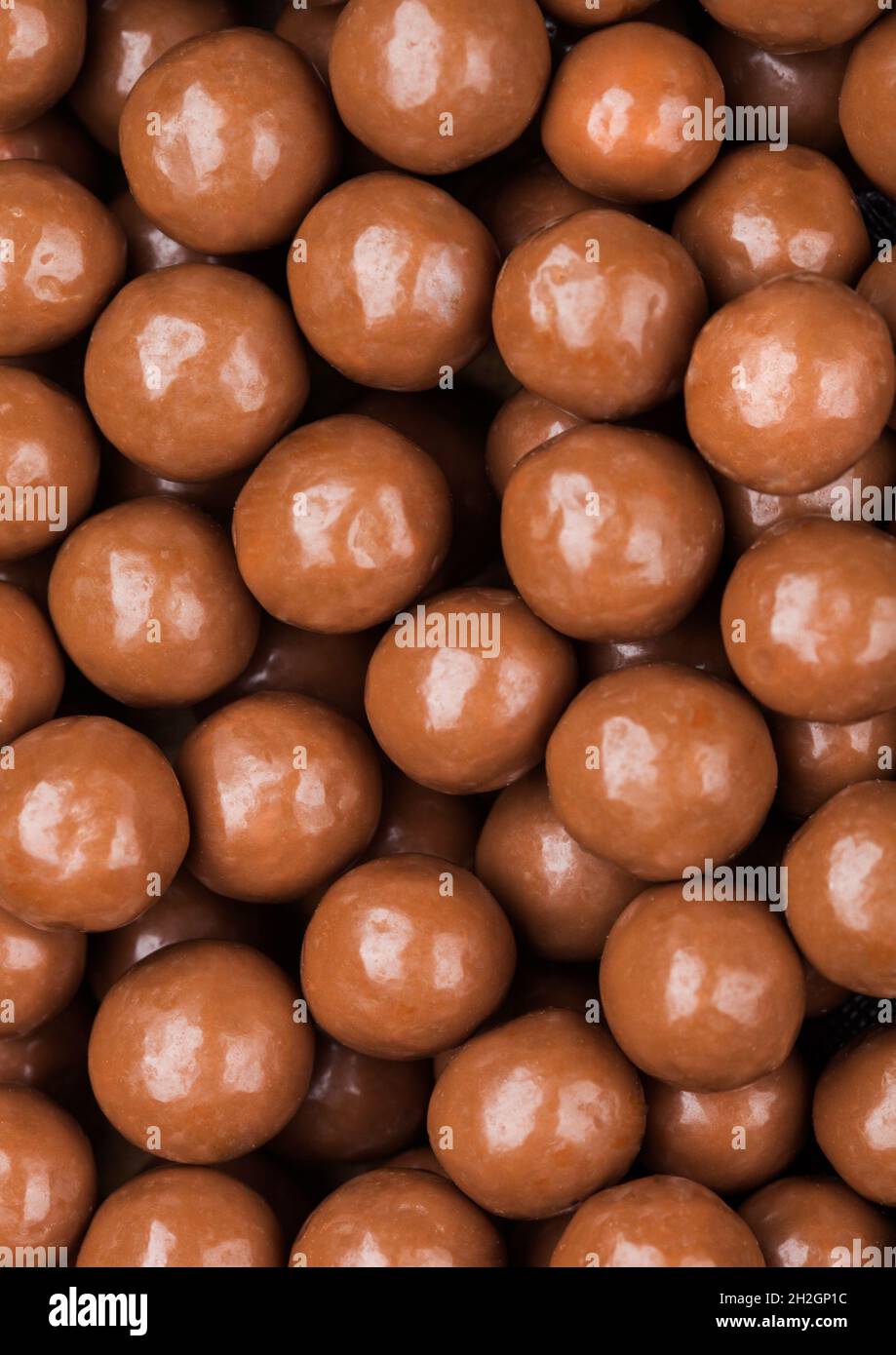 Round crunchy milk chocolate candies to use as background. Macro