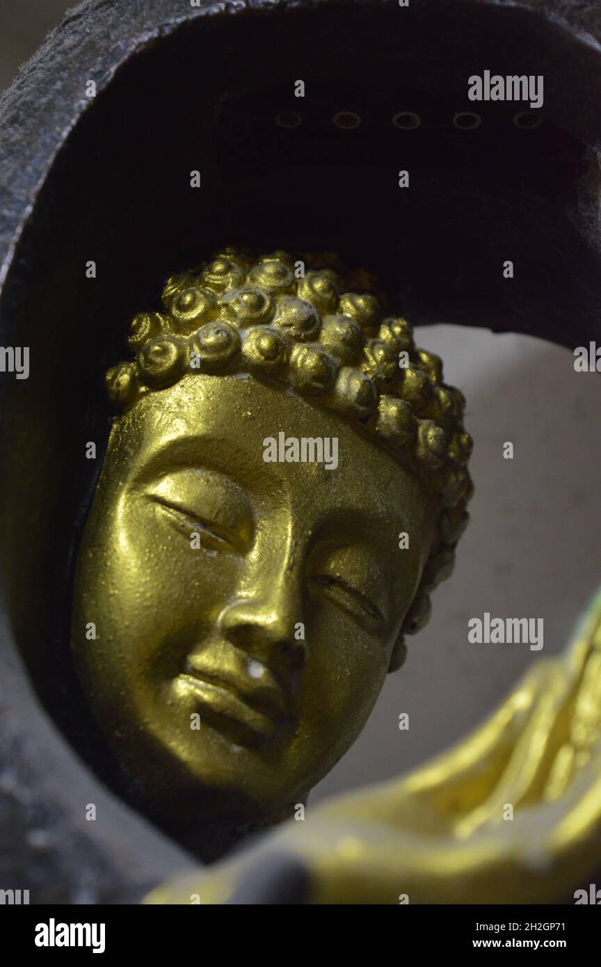 Golden Buddha situated in home with water mechanism along with four different colour lights in it. Stock Photo