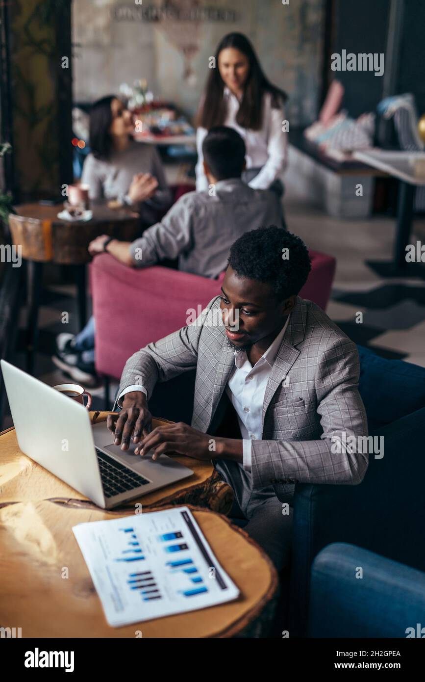 Black business man works in cafe with laptop Stock Photo