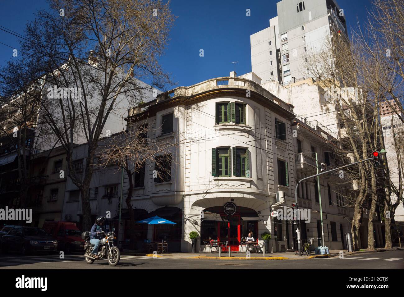 Horizontal view of a man riding a motorbike at Charcas St and Thames St crossing, Palermo neighborhood, Buenos Aires, Argentina Stock Photo