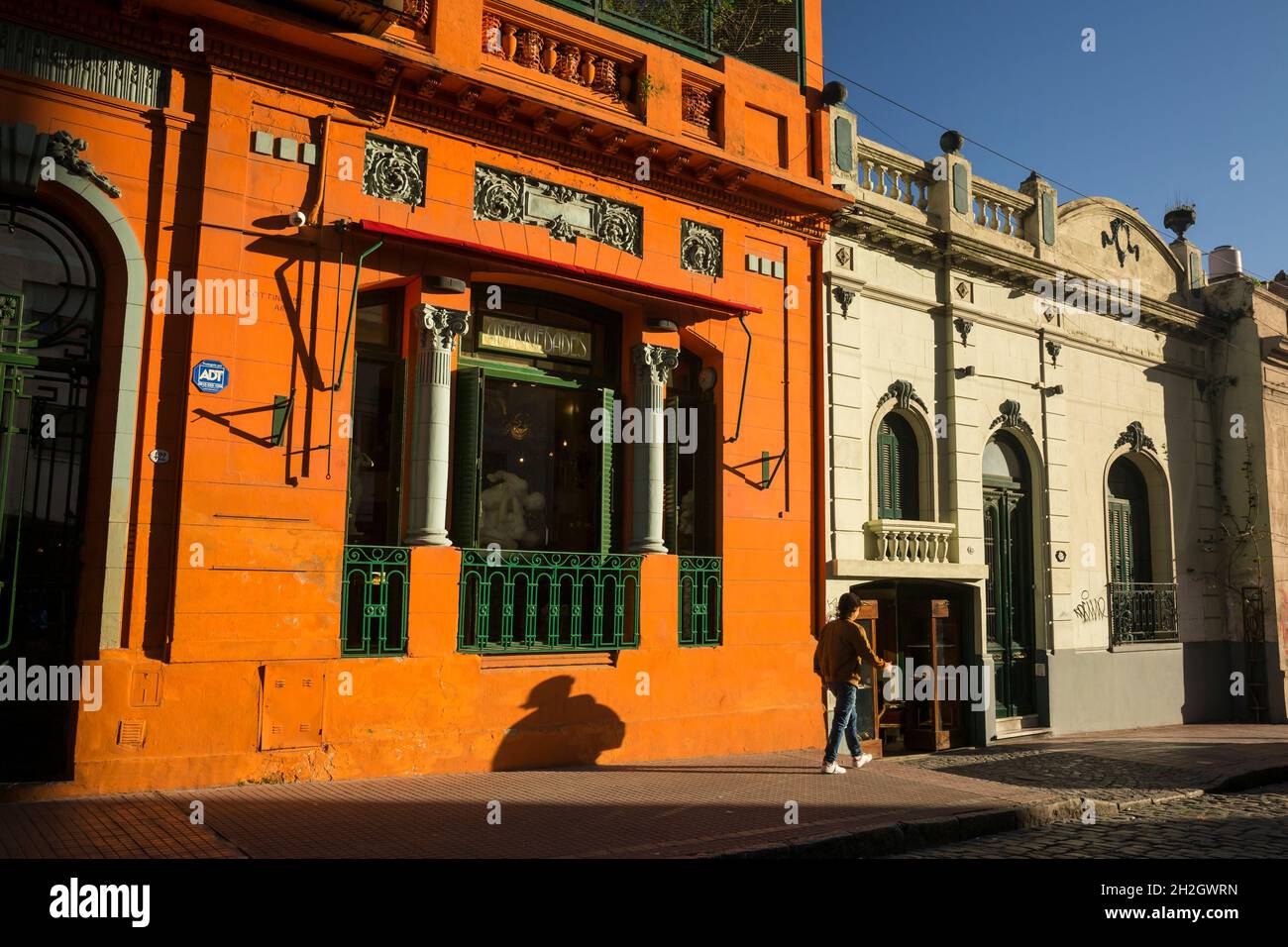 Horizontal view of the orange wall of an antique shop beautifully illuminated by the sun in Carlos Calvo Street, San Telmo neighborhood, Buenos Aires Stock Photo