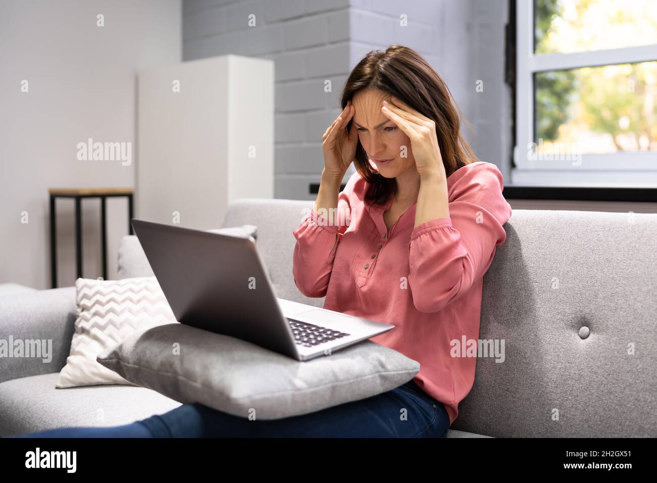 Depressed Business Woman In Home Office With Headache Stock Photo