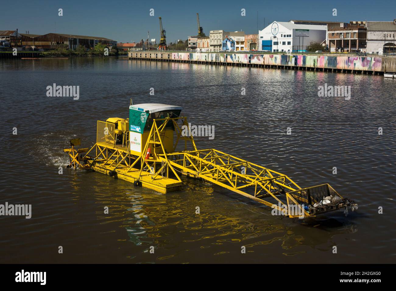 Horizontal view of a waste collector machine over Matanza River (also known as Riachuelo at its mouth in River Plate), La Boca, Buenos Aires Stock Photo