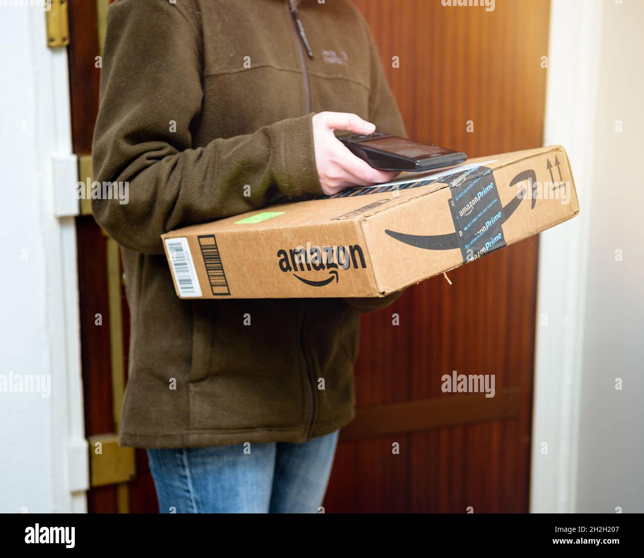 side view of UPS female worker scanning parcel from Amazon Prime