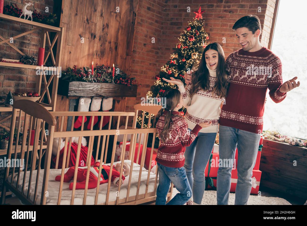 Photo of four people family talk speak enjoy x-mas free time crib baby boy sleep wear sweater in decorated home indoors Stock Photo