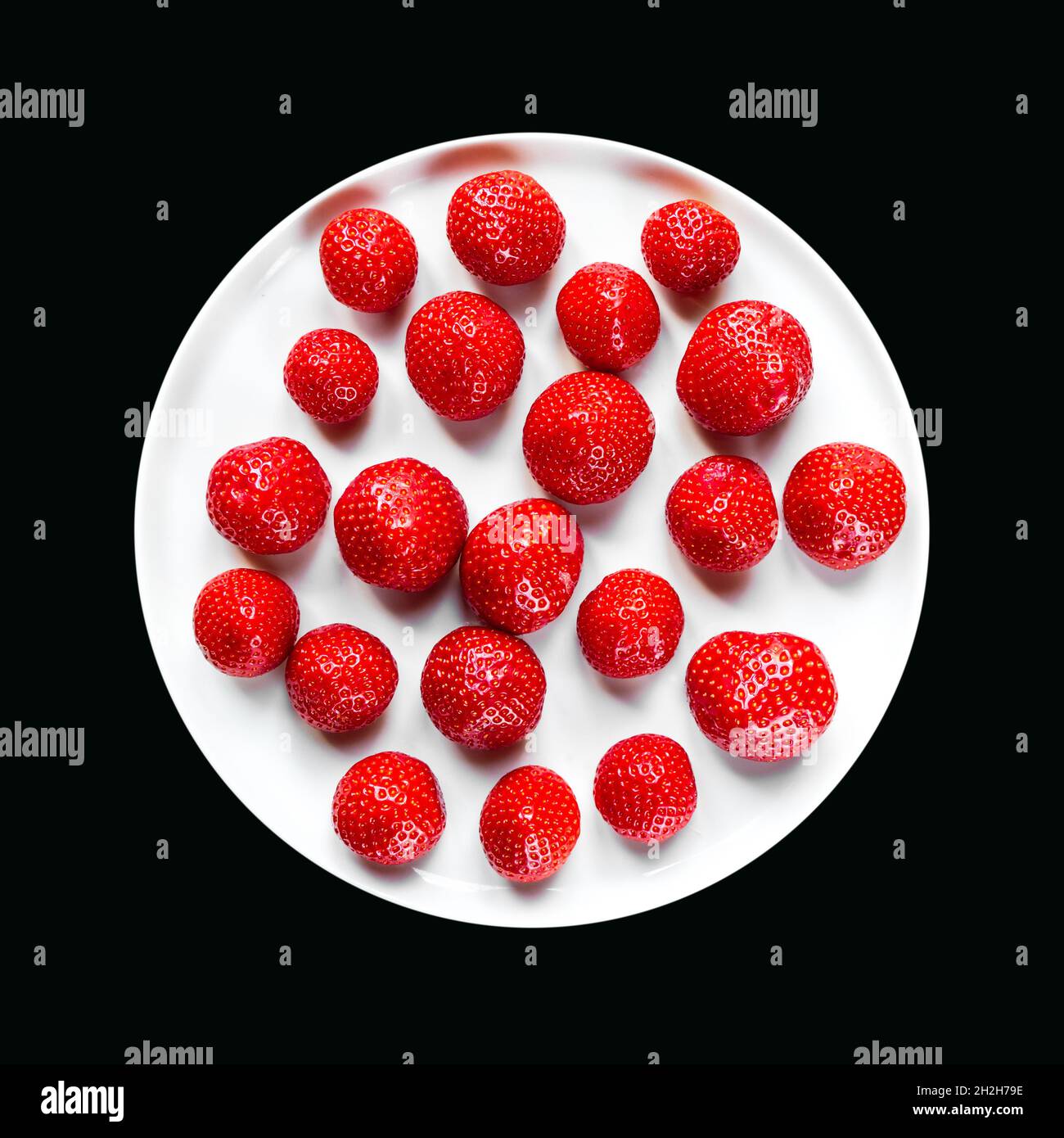 Strawberries in a plate isolated on black background Stock Photo - Alamy