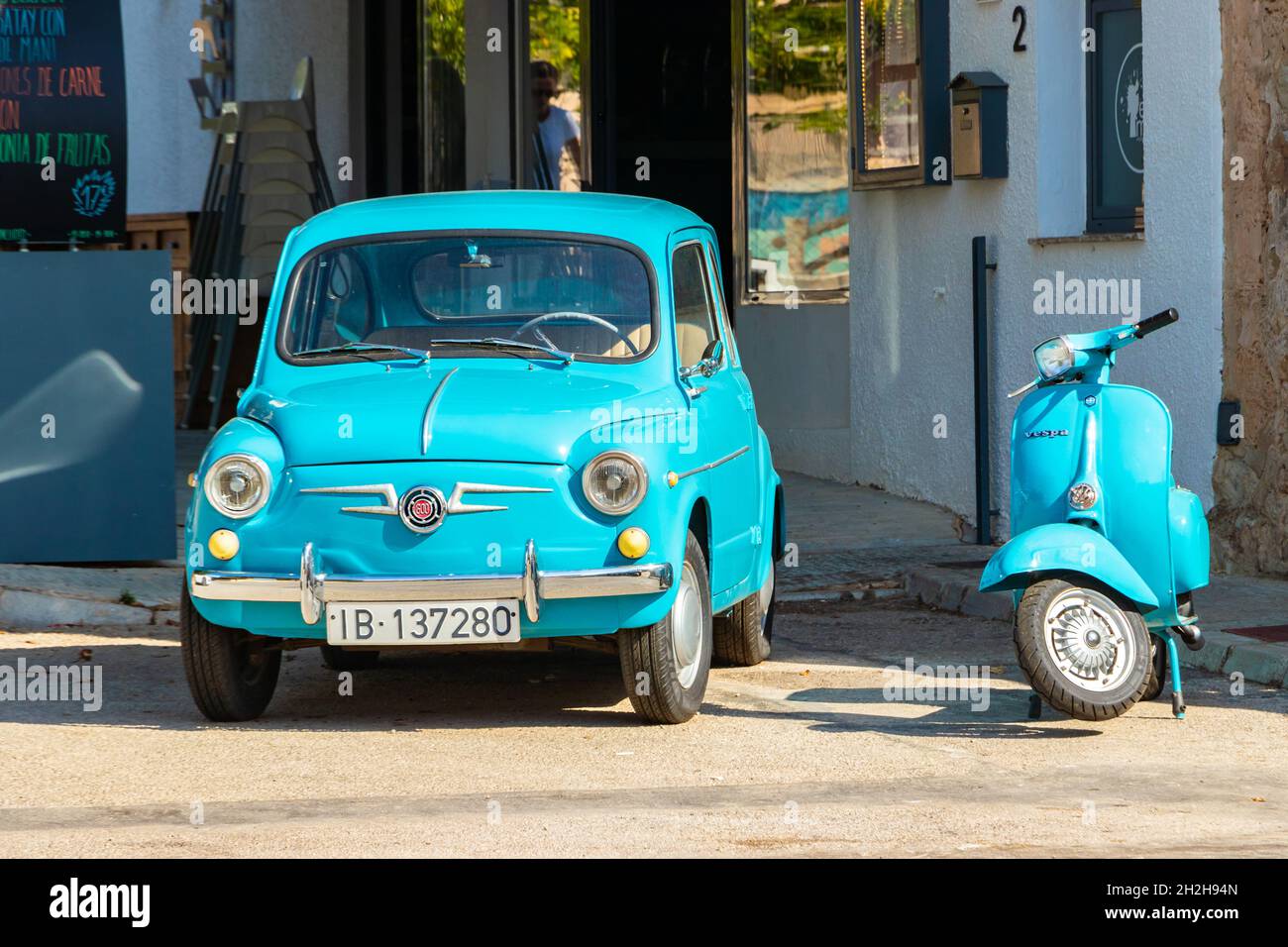 vintage turquoise Fiat 600 and Vespa scooter outside Es Moli restaurant in  Sant Elm Mallorca Stock Photo - Alamy