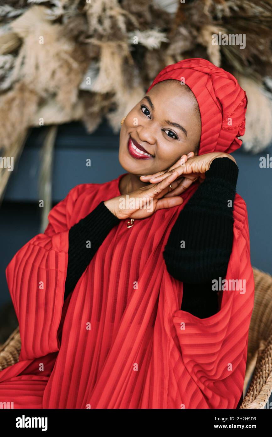 Romantic cute african woman, wearing stylish red dress and headwrap