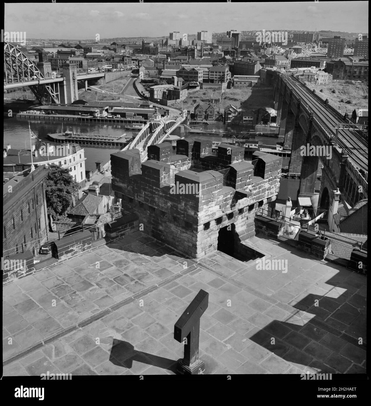 Castle Keep, Castle Garth, Newcastle Upon Tyne, c1955-c1980. A cityscape of Newcastle, looking south over the River Tyne from the roof of Castle Garth Keep. The keep was built between 1168 and 1178, with the roof and battlements added c1811 by Newcastle Corporation. It was later restored c1848 for the Society of Antiquaries of Newcastle. The tower is square in plan with three storeys. In the foreground is the River Tyne, with the Tyne Bridge on the left, Swing Bridge, and High Level Bridge on the right. The image continues looking south. Stock Photo