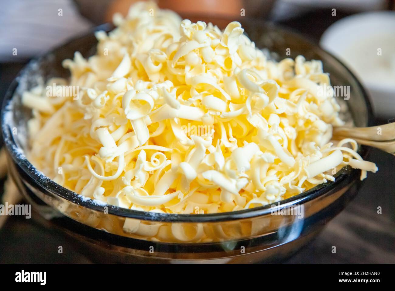 Grated butter for baking on table. Baking ingredients for shortbread pastry: grated butter, flour, eggs, sour cream on a wooden background. Stock Photo