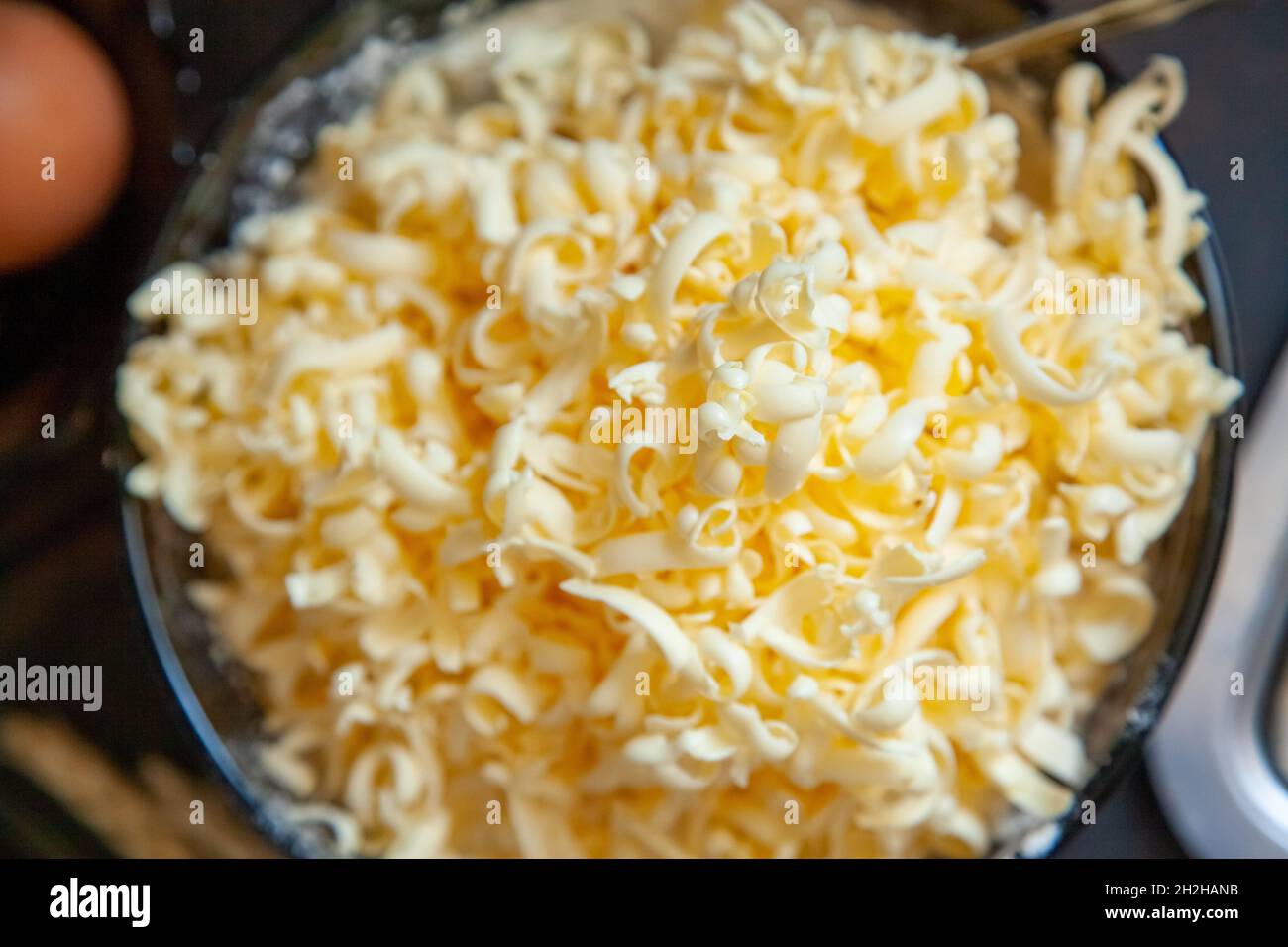 Grated butter for baking on table. Baking ingredients for shortbread pastry: grated butter, flour, eggs, sour cream on a wooden background flat lay. Stock Photo