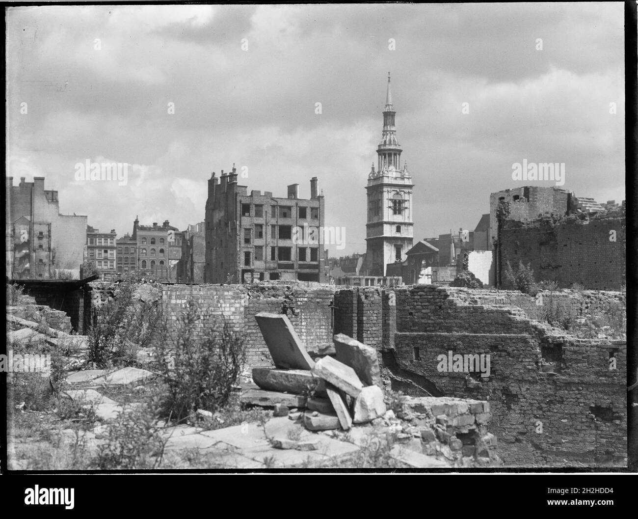 St Mary-le-Bow Church, Cheapside, City and County of the City of London, Greater London Authority, 1941-1945. A view looking north-east across a bomb damaged landscape towards St Mary-le-Bow Church. St Mary-le-Bow was rebuilt by Christopher Wren after the Great Fire of London in 1666. During the Second World War it was almost destroyed by bombing on 10th May 1941 with incendiary bombs causing a fire which sent the bells in its tower crashing down to the ground. The tower was left standing and restoration of the church began in 1956. Stock Photo