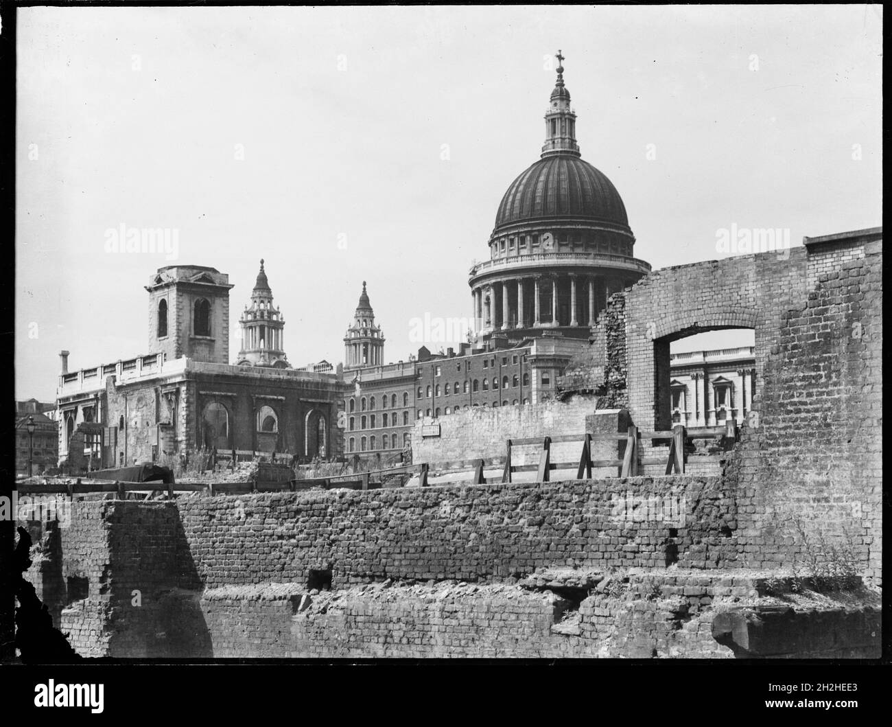 St Paul's Cathedral, St Paul's Churchyard, City of London, City and County of the City of London, Greater London Authority, 1941-1945. A view looking north-west across a bomb damaged landscape towards St Paul's Cathedral with St Nicholas Cole Abbey on the left of the foreground. St Nicholas Cole Abbey was rebuilt by Christopher Wren after the Great Fire of London in 1666. During the Second World War it was again badly damaged by bombing and lay in ruins until it was restored in 1962. Stock Photo