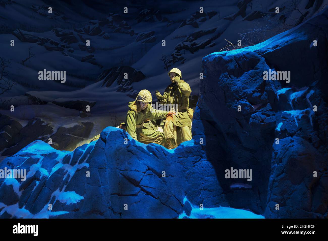 Two soldiers, one wounded, call for help in the snowy mountains during a cold winter of the Korean War. At the National Museum of the Marine Corps Her Stock Photo