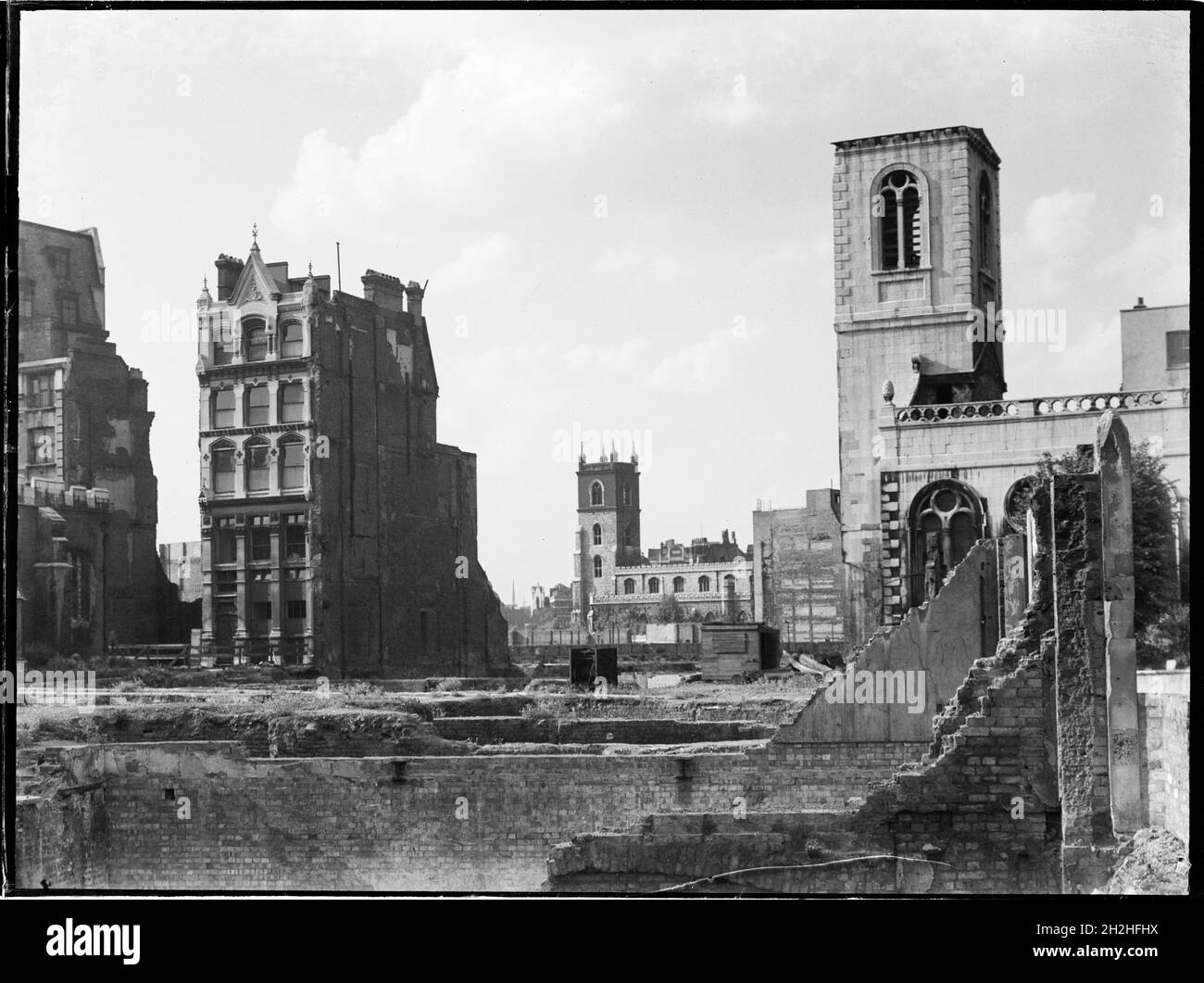 St Giles' Cripplegate, Fore Street, City and County of the City of London, Greater London Authority, 1941-1945. A view looking north-west across a bomb damaged landscape towards St Giles' Cripplegate Church in the distance with St Mary Aldermanbury on the right of the foreground. St Mary Aldermanbury which was rebuilt by Christopher Wren after the Great Fire of London in 1666 was later gutted by fire during the Blitz in 1940. The remains of the walls were removed and rebuilt in Fulton, Missouri in 1966 as a memorial to Winston Churchill, although the footings of the church remain on the origin Stock Photo