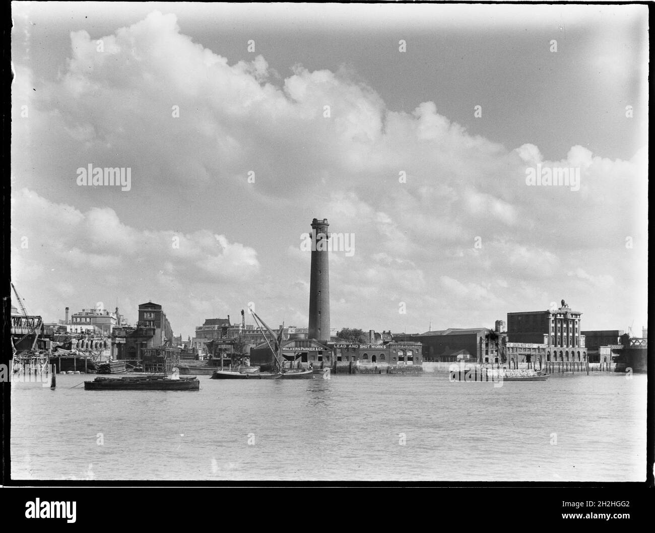 Shot Tower and Lead Works, Belvedere Road, Lambeth, Greater London Authority, 1936. A view across the River Thames towards the shot tower at Lambeth Lead Works with the Lion Brewery on the right. The shot tower of the Lambeth Lead Works was designed by David Ridall Roper and was built in 1826 for Thomas Maltby &amp; Co. At the time of this photograph it was operated by Walkers, Parker &amp; Co but it was later demolished in 1962 to make way for the Queen Elizabeth Hall. The Lion Brewery was built in 1836-37 but was later demolished in 1949 to make way for the Royal Festival Hall. Stock Photo