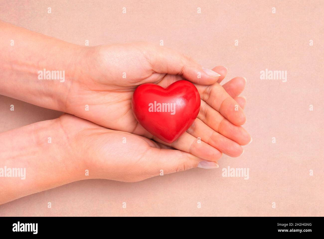 Health care concept with heart in hands. Heart as a symbol of caring and care Stock Photo