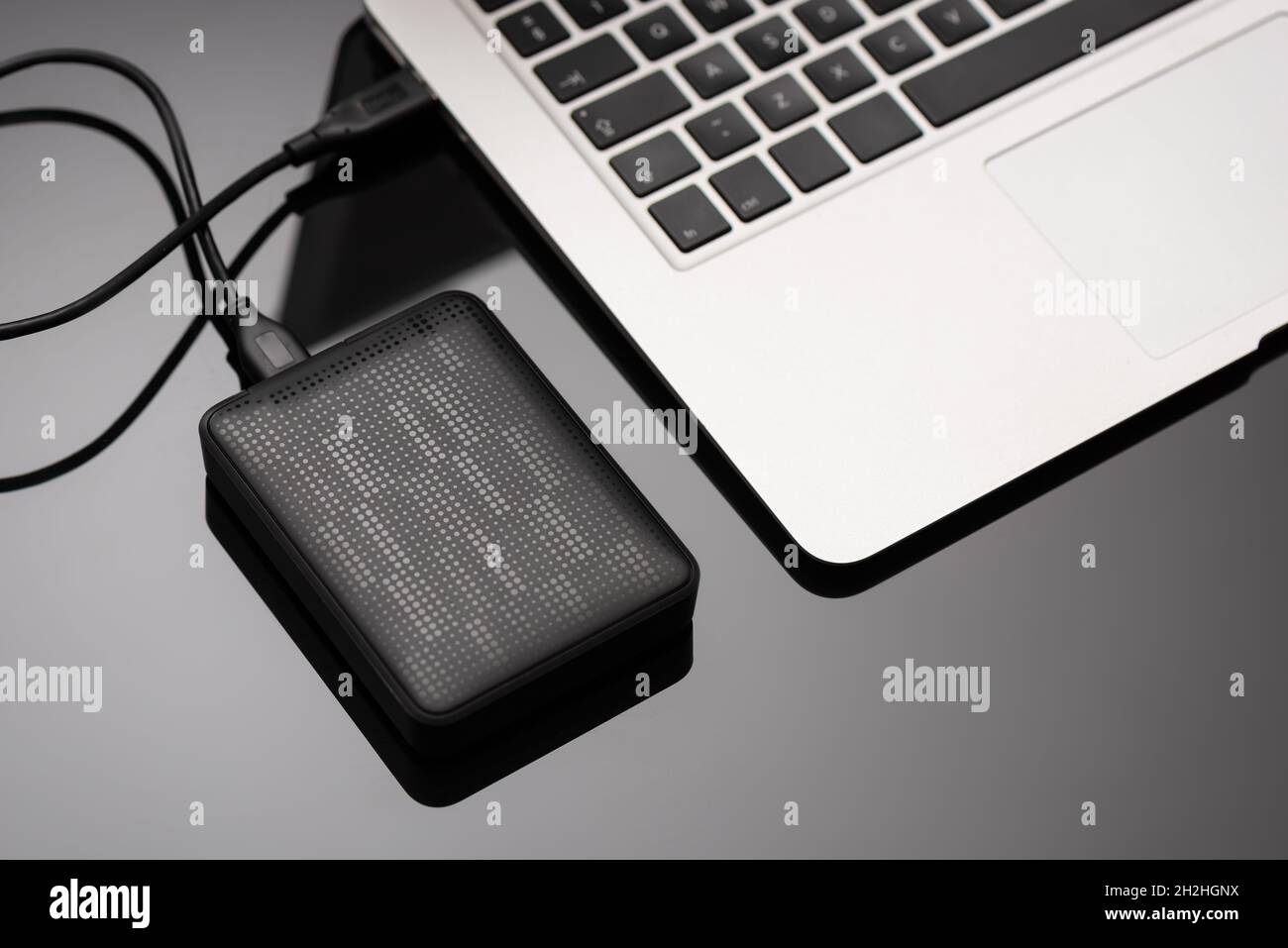 External backup disk hard drive connected to laptop Stock Photo