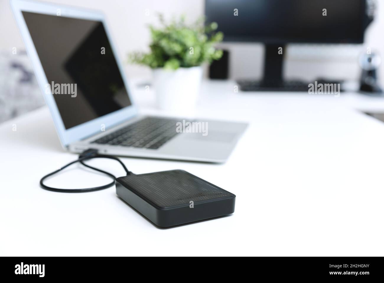 External backup disk hard drive connected to laptop Stock Photo