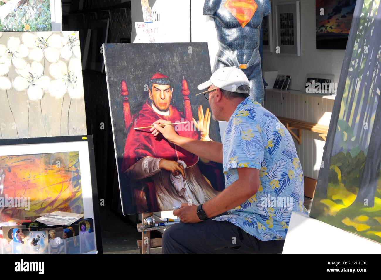 Artist putting the finishing touch to a portrait of Mr Spock or Leonard Nimoy dressed as a Cardinal on the seafront in Brighton East Sussex England UK Stock Photo