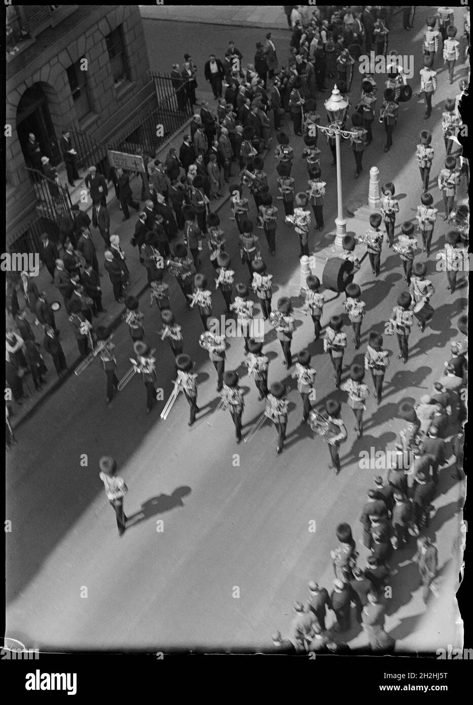 Funeral procession of a serviceman awarded the Victoria Cross, Greater London Authority, early 1930s. Looking down from a tall building towards a military band marching in the funeral procession of a serviceman awarded the Victoria Cross. On notes within the collection file, this photograph was given a title of 'Death of a Hero'. The parade appears to have been for the funeral of a soldier who had been awarded a Victoria Cross. The notes also mention that the photograph was exhibited at the Royal Photographic Society and reproduced in Woman's Journal, July 1933. Stock Photo