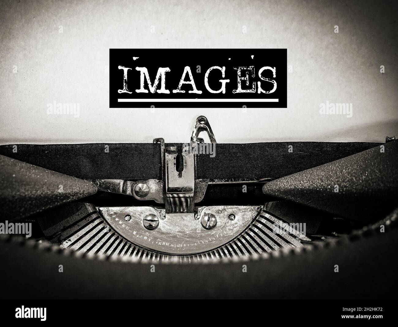 Images displayed on a vintage typewriter with underscore and black border around text in a sepia tone Stock Photo