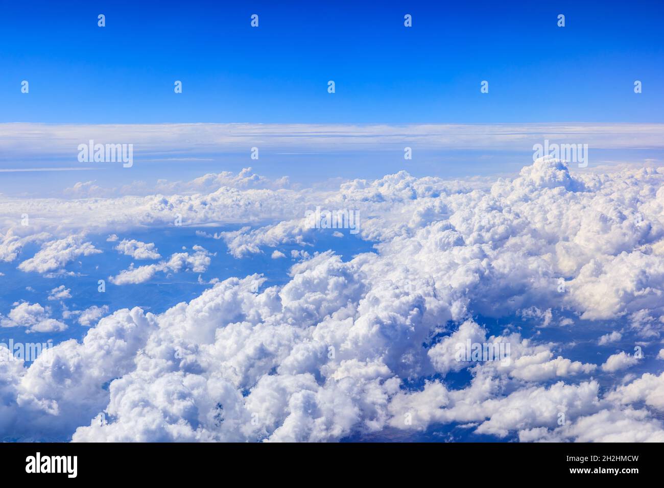 Commercial airplane flying above blue sky and white clouds Stock Photo ...