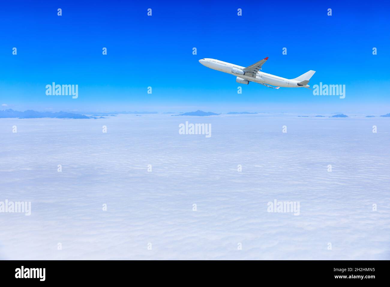 Commercial airplane flying above blue sky and white clouds Stock Photo ...