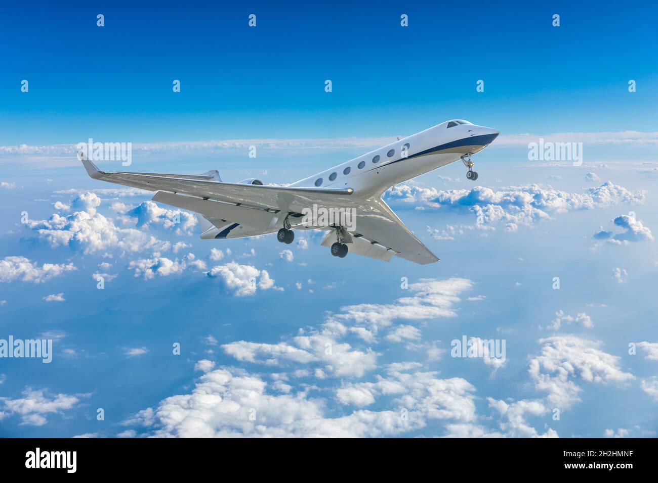 Commercial airplane flying above blue sky and white clouds Stock Photo ...