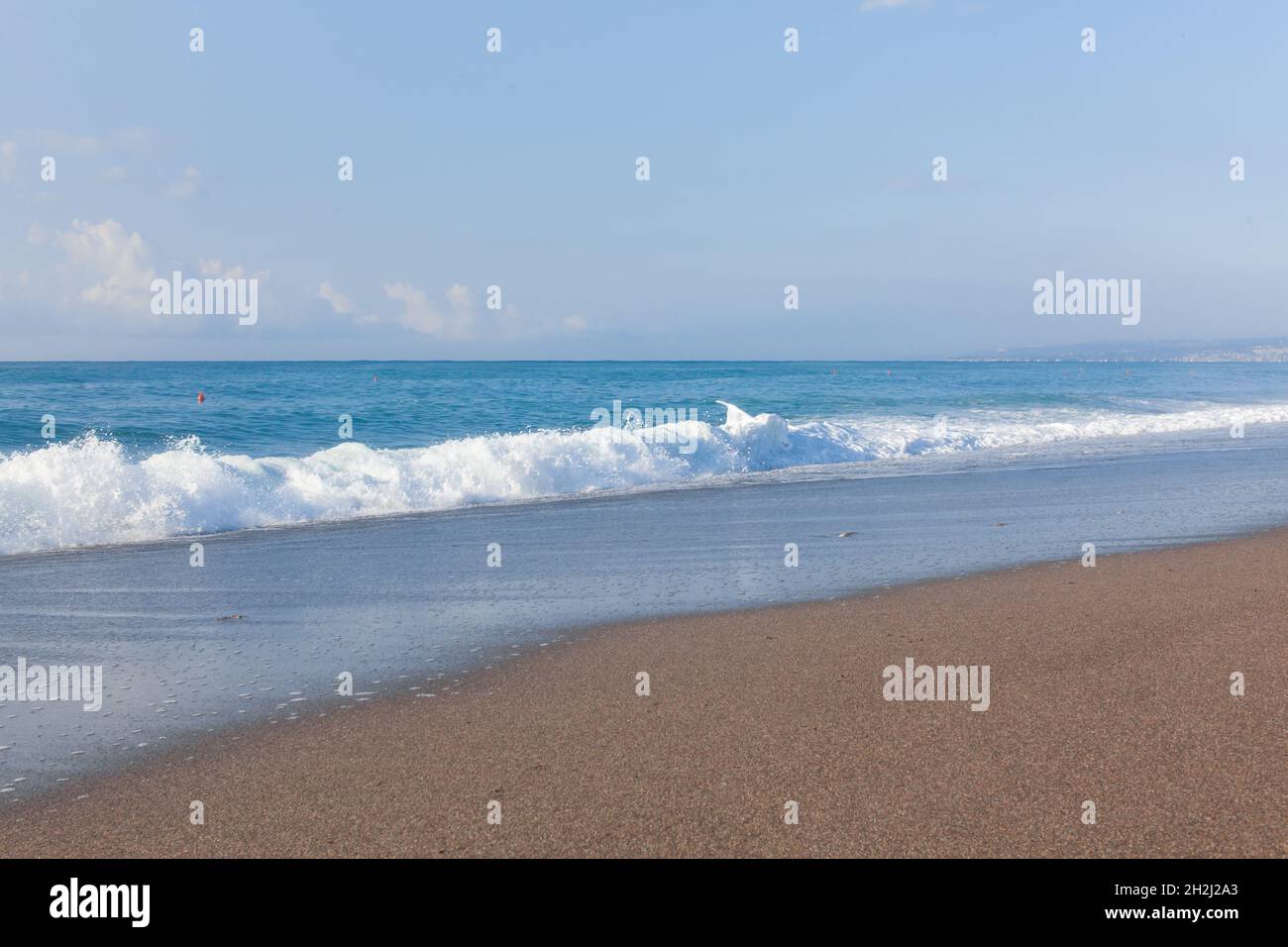 Waves on the beach. Sand and blue water. Sicily, Italy. Stock Photo