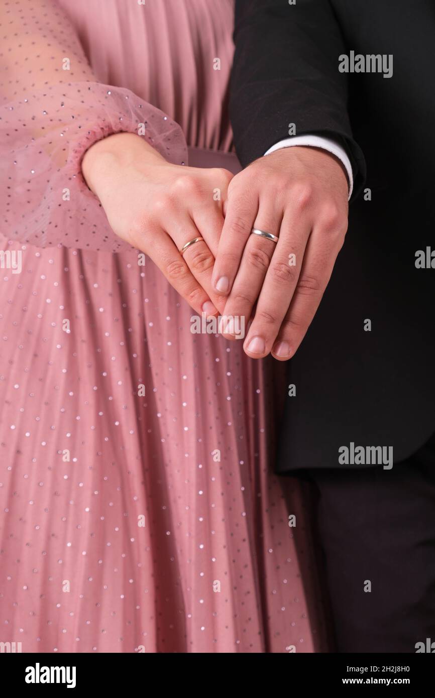 Hands of the bride and groom with wedding rings of white and yellow gold close-up Stock Photo