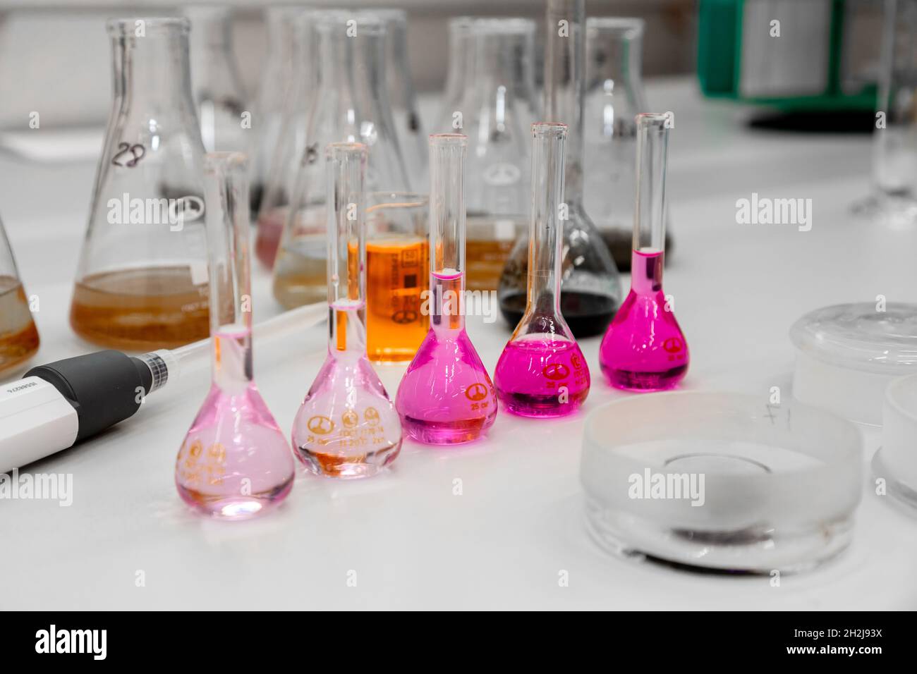 Composition of laboratory material with colored liquids in realistic glass pots Stock Photo