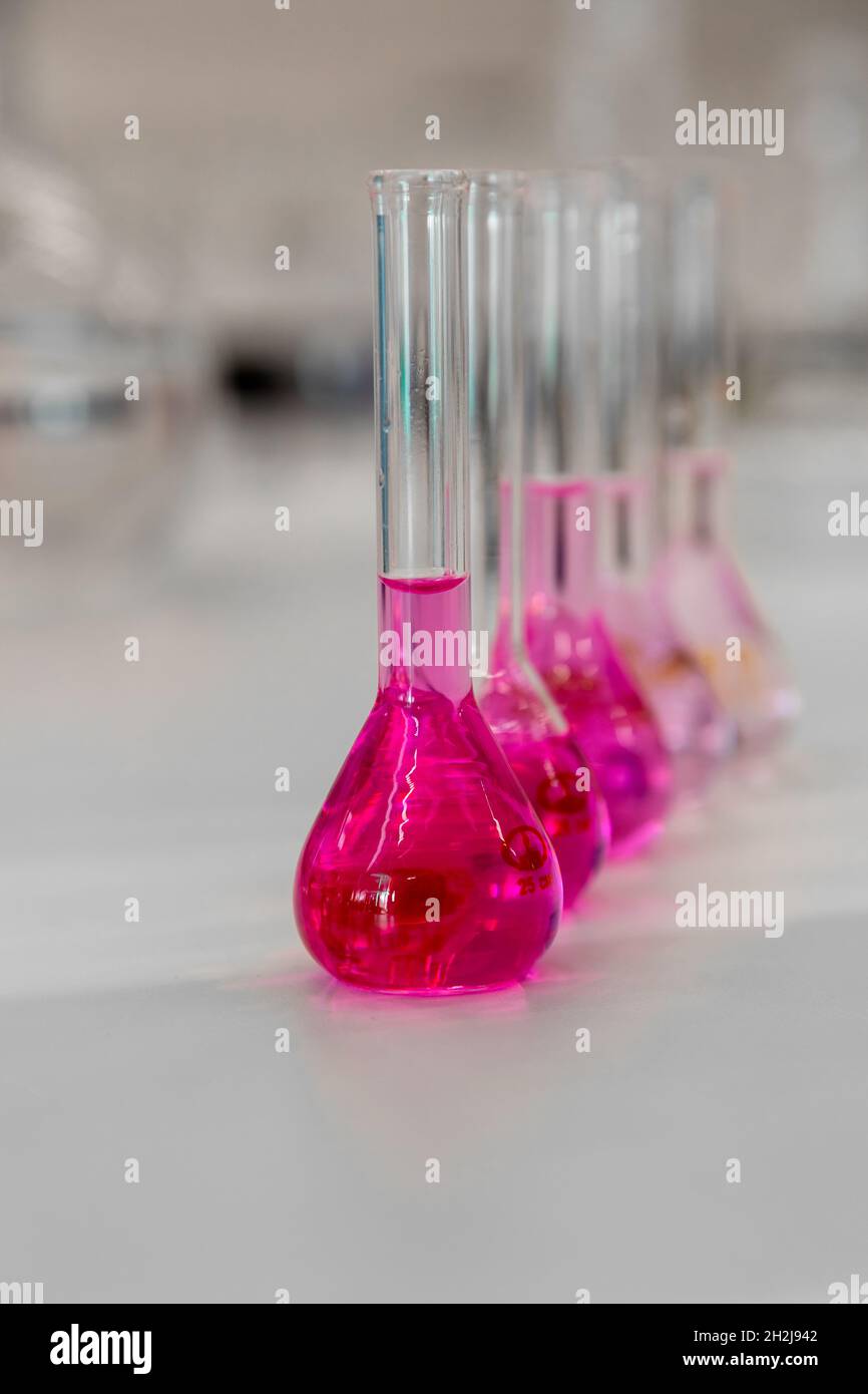 Composition of laboratory material with colored liquids in realistic glass pots Stock Photo