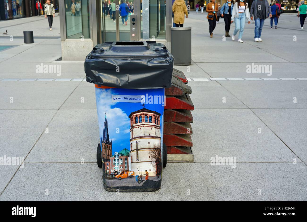 Clean trash can with colourful Düsseldorf photo print on the shopping mile Schadowstraße in Düsseldorf/Germany, to encourage environmental awareness. Stock Photo