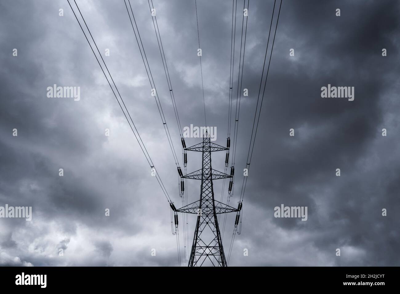 An electricity power supply pylon set against a heavily clouded grey sky, Worcestershire, England. Stock Photo